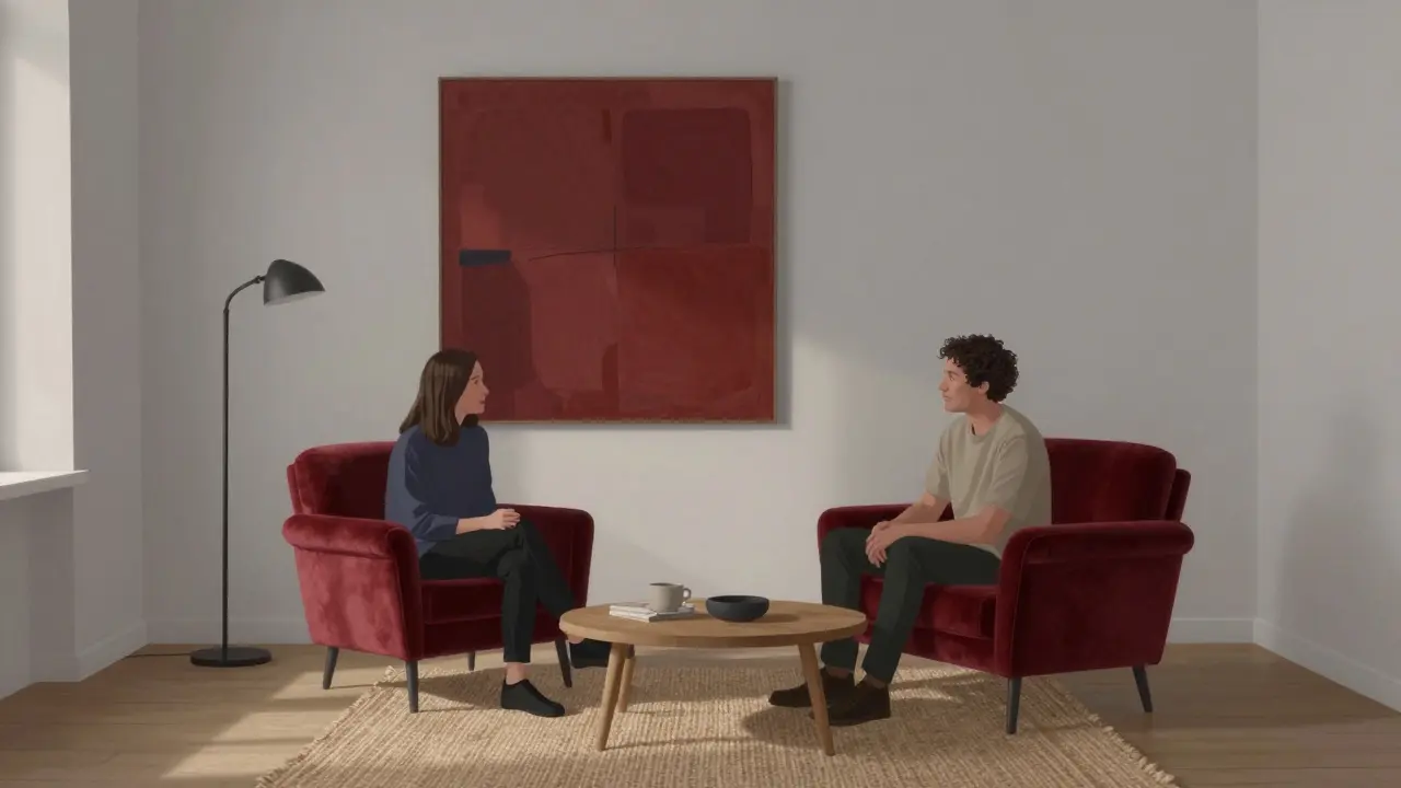 Obývací pokoj s červeným křeslem, šedými stěnami a přírodními textiliemi v klidném večerním osvětlení.